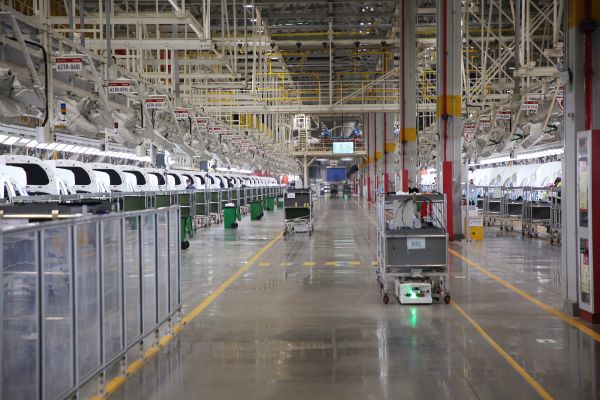 自動化牽引小車穿行在北汽株洲基地二工廠的總裝車間里。