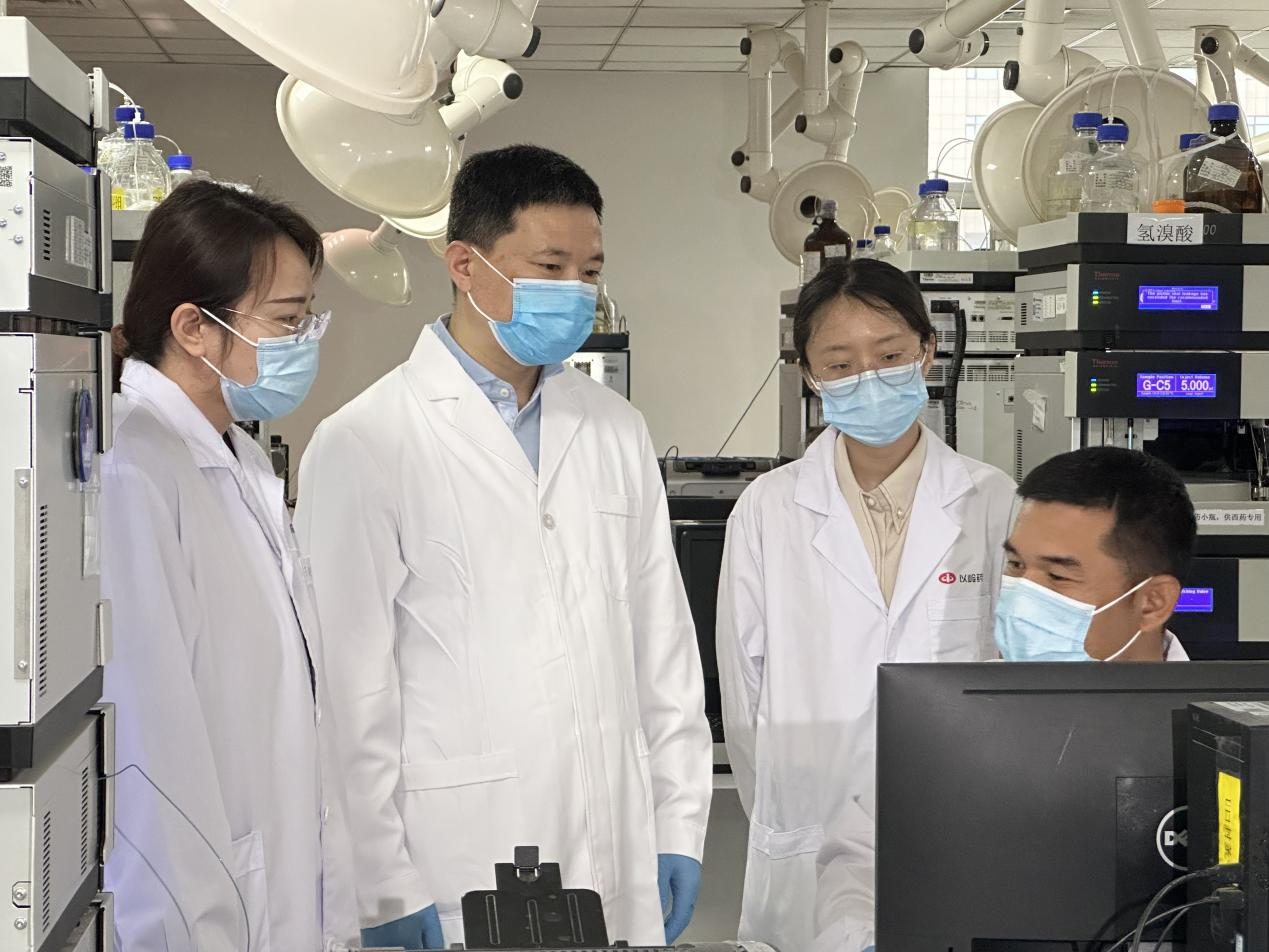 賈振華（左二）與科研人員在討論業(yè)務(wù)。 孫陽陽攝