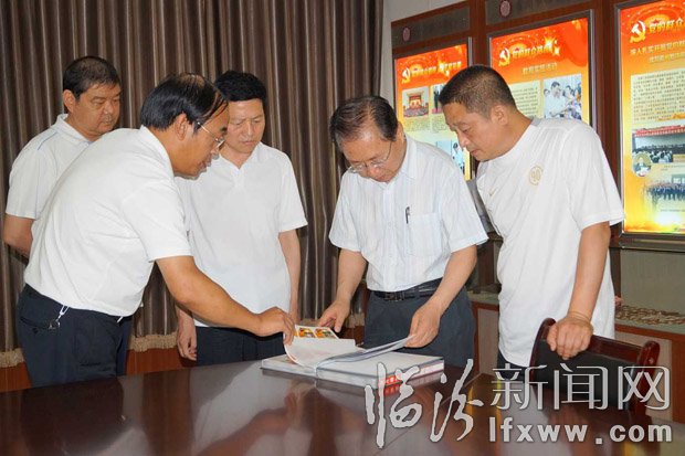 梁組長(zhǎng)一行在查閱照片檔案。